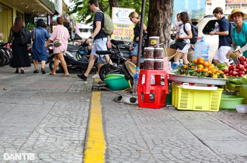 Bà Lan đang sửa lại sạp trái cây bán trên vỉa hè đường Phan Chu Trinh, phường Bến Thành (Ảnh: An Huy).