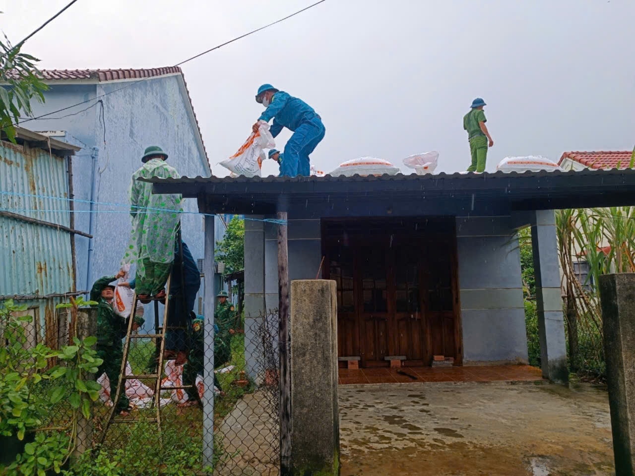 Lực lượng công an phối hợp với dân quân tổ chức chằng chống nhà cho người dân.