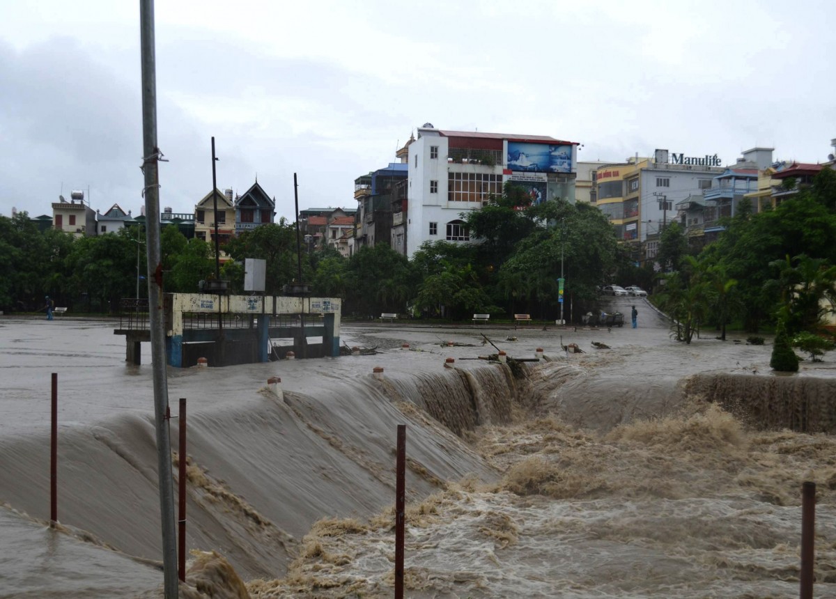 Tính đến 10 giờ, ngày 2/8, mưa lớn kéo dài đã khiến 500 nhà dân ở khu vực trung tâm thành phố Uông Bí (Quảng Ninh) đã bị ngập sâu trong nước. Lũ tràn cao qua các đập, ngầm ở xã Thượng Yên Công của thành phố Uông Bí khiến xã này đang bị cô lập. Hiện trên toàn thành phố chưa có thiệt hại về người. Trước tình hình trên, thành phố Uông Bí đã huy động trên 50 chiến sỹ lực lượng bộ đội và công an cùng các lực lượng của phường Vàng Danh, xã Thượng Yên Công và Ban Quản lý Di tích và Rừng Quốc gia Yên Tử tổ chức, bố trí lực lượng kiểm soát, cắm các biển báo và huy động 120m rào chắn; bố trí 6 barie tại các đập tràn xung yếu; 60m barie di động để hướng dẫn giao thông tại các khu vực nước ngập sâu, chảy xiết; huy động trên 2.000m2 vải bạt để che các bờ taluy có nguy cơ sạt lở. Trong ảnh: Khu vực trung tâm TP Uông Bí nước đang dồn về làm ngập sâu. Ảnh: Nguyễn Hoàng-TTXVN