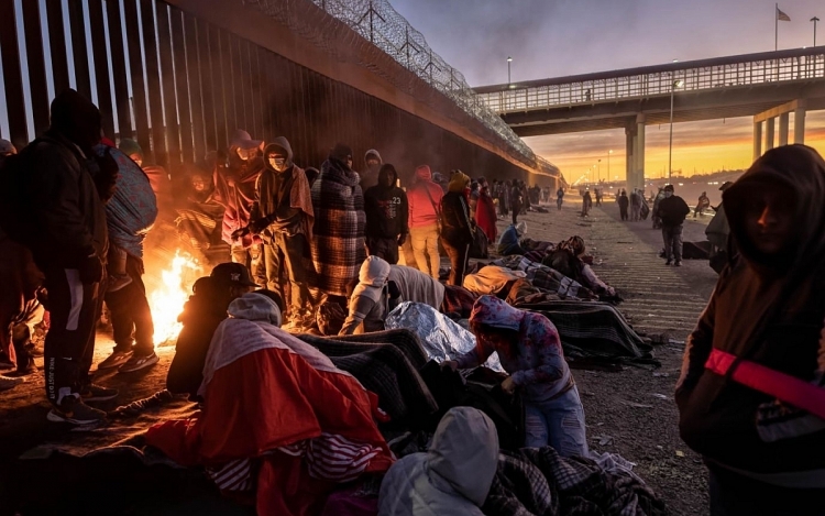 Người di cư tập trung đốt lửa sưởi ấm hôm 22/12 bên cạnh hàng rào biên giới Mỹ - Mexico ở El Paso, Texas.