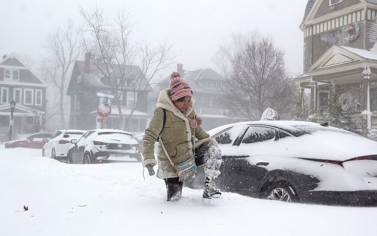 Người phụ nữ ở Buffalo, ngoại ô New York, chật vật di chuyển trên đường phố khi lớp tuyết phủ dày kín tới đầu gối, hôm 24/12.