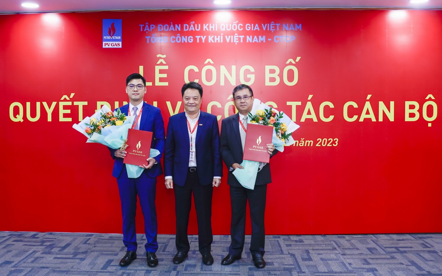 Tổng Giám đốc PV GAS Hoàng Văn Quang trao quyết định và tặng hoa chúc mừng 2 cán bộ vừa nhận quyết định mới của PV GAS