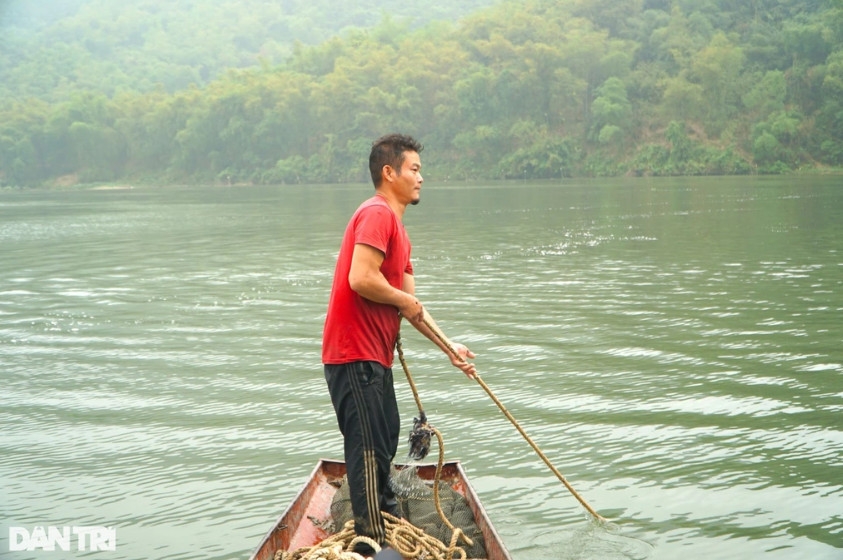 Sau khi chạy thuyền vòng quanh sông, những người thợ cào hến sẽ kéo chiếc cào bằng sắt lên khoang thuyền.