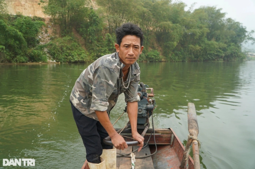Anh Ngô Văn Bình lái thuyền máy ngược dòng sông Mã để cào hến.
