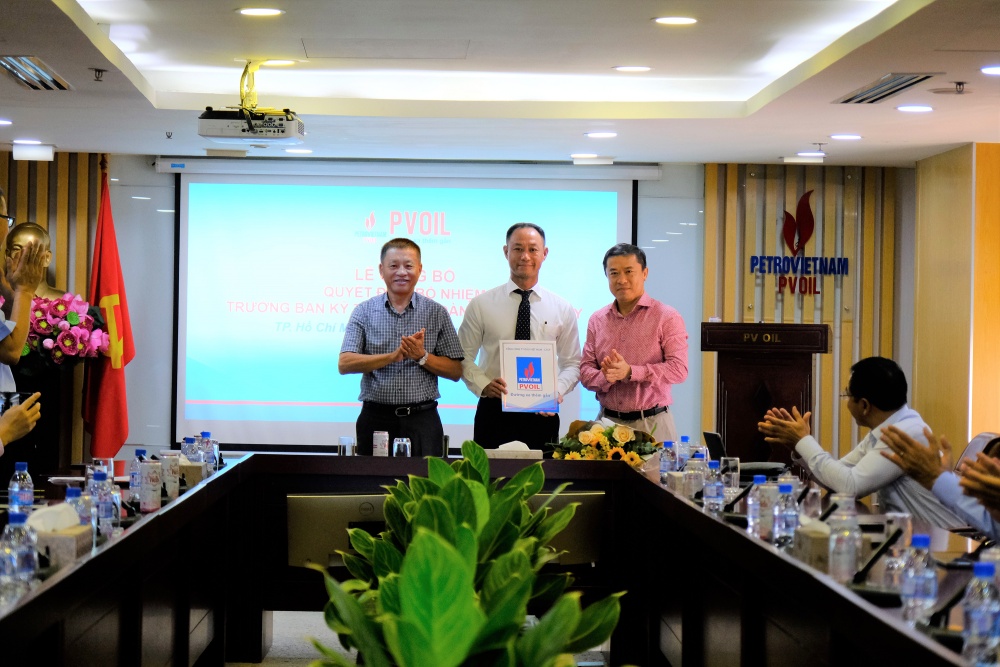 Ông Đoàn Văn Nhuộm – Tổng Giám đốc PVOIL (bên trái) và ông Võ Khánh Hưng – Phó Tổng Giám đốc PVOIL (bên phải) trao Quyết định và tặng hoa chúc mừng ông Nguyễn Duy Long