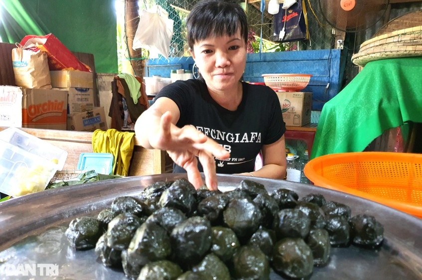 Bàn tay gói bánh thoăn thoắt của chủ lò Trần Thị Lộc, chỉ hơn 10 giây hoàn thành một chiếc bánh.