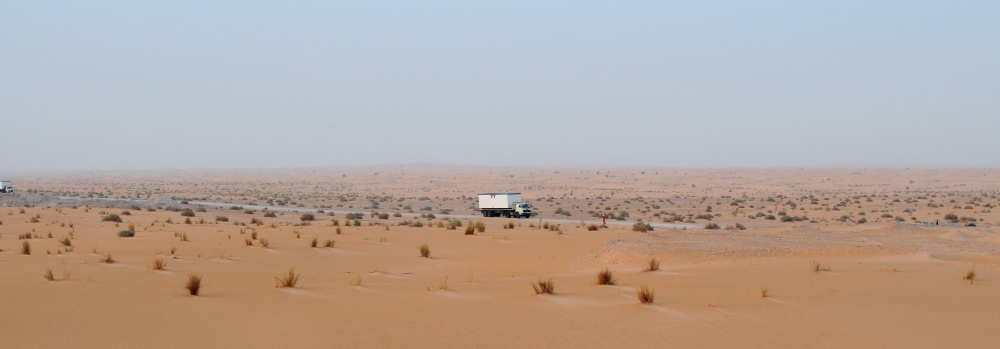 18-DQL-AB-0001-02: Xe chuyên chở container nhà ở ra khoan trường, giữa sa mạc Sahara mênh mông, cả xe và nhà dường như rất nhỏ bé trên con đường dài xuyên sa mạc.