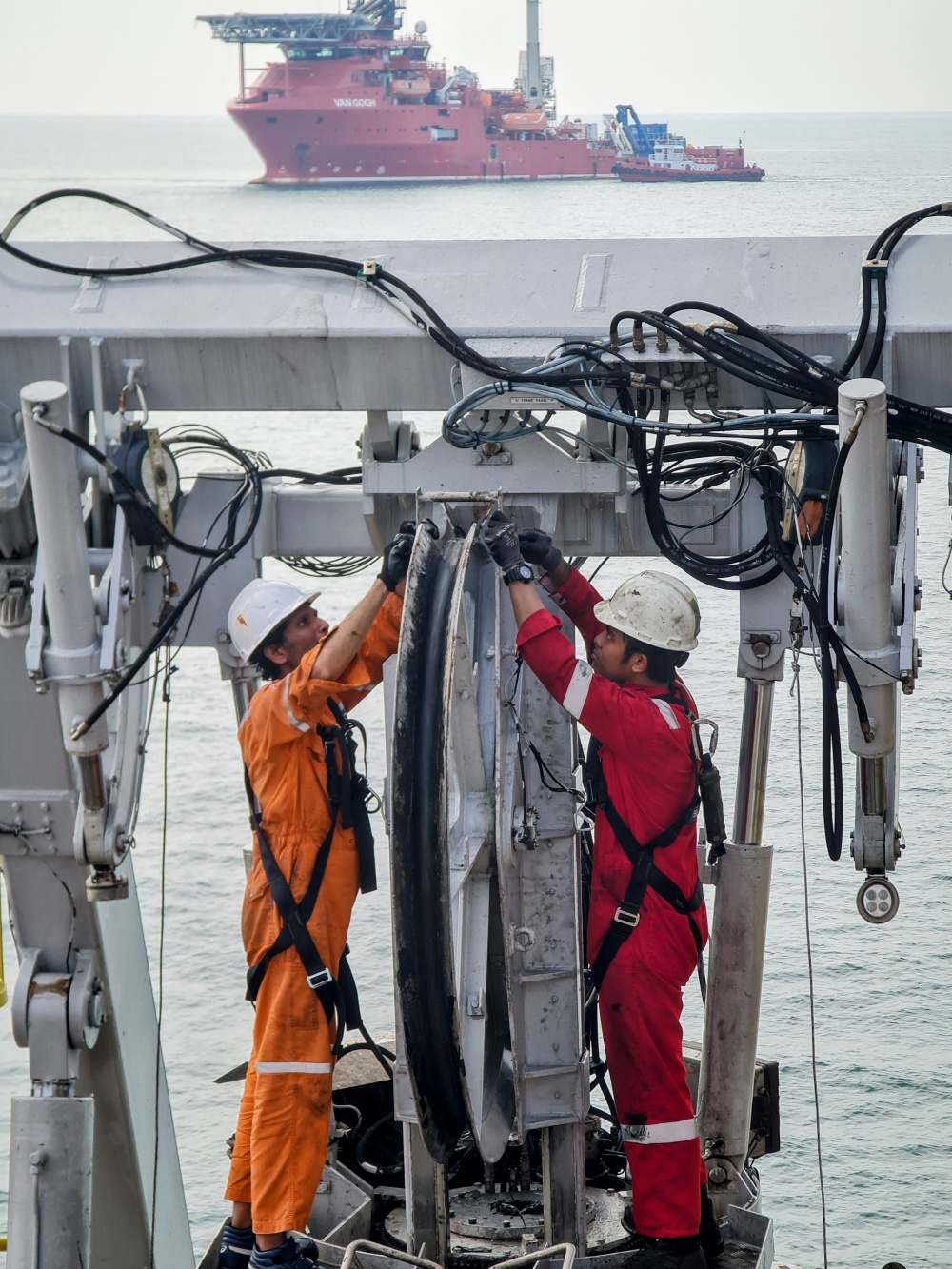 20-TNT-AB-0004-07: Hai kỹ thuật viên đang bảo trì hệ thống Rô-bốt lặn (ROV) cho tàu Crest Odyssey 1, một cuộc hội ngộ tình cờ với tàu phía đằng xa Van Gogh - một tàu khác cũng được PTSC Offshore Service sử dụng cho dự án thu hồi đường ống và kết cấu tại V