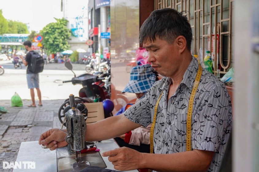 Anh Phước hằng ngày đều ngồi sửa quần áo ở góc đường Nguyễn Trãi (quận 5, TPHCM) (Ảnh: Nguyễn Vy).