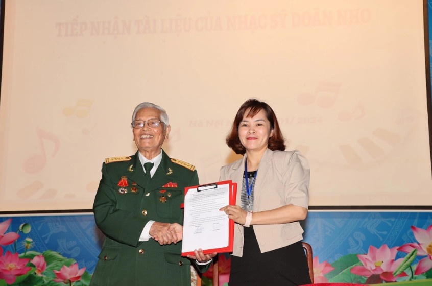 Giám đốc Trung tâm Lưu trữ quốc gia III Trần Việt Hoa tiếp nhận tài liệu của nhạc sĩ Doãn Nho (Ảnh: Ban Tổ chức).