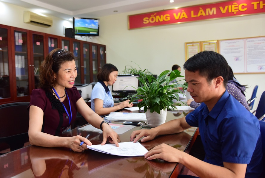 Cán bộ bộ phận “một cửa” phường Việt Hưng (quận Long Biên) nhiệt tình hướng dẫn người dân làm thủ tục hành chính.