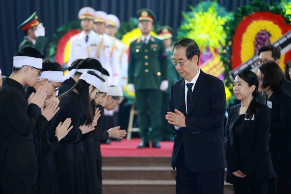 Thủ tướng Hàn Quốc Han Duck Soo đi quanh linh cữu và chia buồn cùng thân nhân gia đình Tổng Bí thư Nguyễn Phú Trọng (Ảnh: TTXVN).