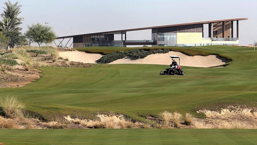một nhân viên đang cắt cỏ trước câu lạc bộ tại Câu lạc bộ Golf Quốc tế Trump, ở Dubai, Các Tiểu vương quốc Ả Rập Thống nhất.