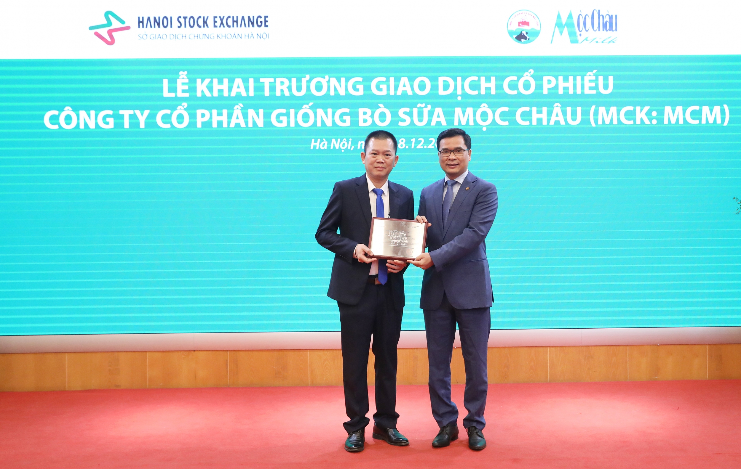 Lãnh đạo Sở Giao dịch chứng khoán Hà Nội (phải) trao chứng nhận đăng ký giao dịch cho Tổng giám đốc công ty Mộc Châu Milk (trái)