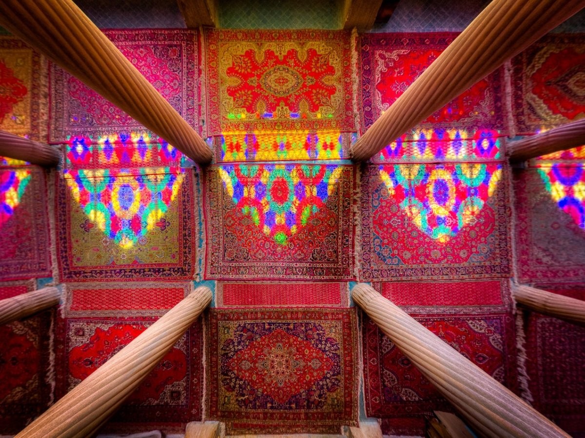 Màu sắc phản chiếu qua kính cửa sổ nhảy múa trên những tấm thảm rực rỡ sắc màu.