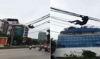 [VIDEO] Thanh niên đu dây điện sang đường ở Hà Nội