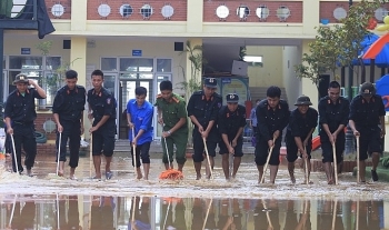 Cảnh sát PC&CC và CSCĐ giúp dân vùng ngập lụt dọn vệ sinh