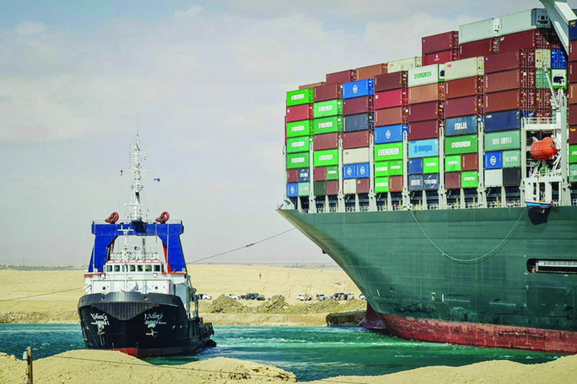 Tàu Ever Given mắc cạn tại Kênh đào Suez làm tắc nghẽn giao thông hàng hải đã khiến cho chi phí vận tải tăng cao, giá hàng hóa nhập khẩu cũng tăng theo. Ảnh: EPA
