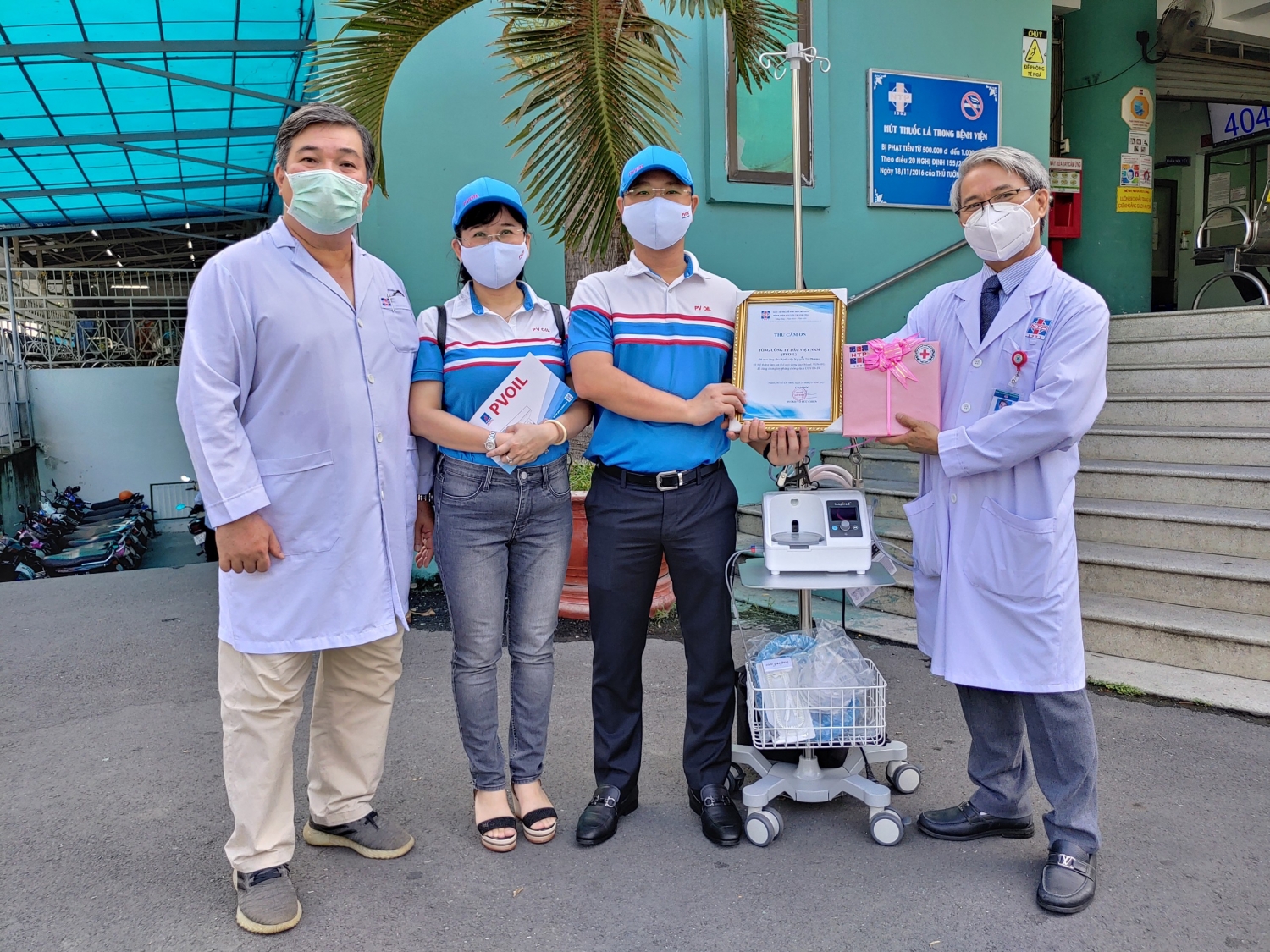 BS CKII Võ Đức Chiến - Giám đốc Bệnh viện Nguyễn Tri Phương (bên phải) tiếp nhận máy thở oxy dòng cao do PVOIL trao tặng