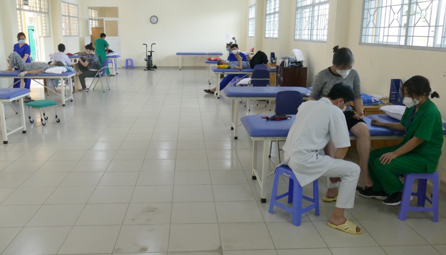 Các kỹ thuật viên hỗ trợ bệnh nhân tập các bài tập vật lý trị liệu. Ảnh: VGP/Nguyễn Kim
