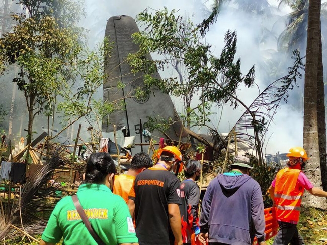Lực lượng cứu hộ tìm kiếm các thi thể trong vụ nơi máy bay C-130. (Ảnh: AP)