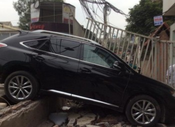 Nữ tài xế tông đổ tường tiệm rửa xe