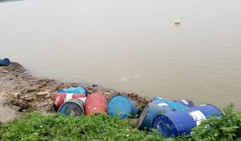 Nhiều thùng phuy nghi chứa chất độc hại bị vứt xuống sông Hồng