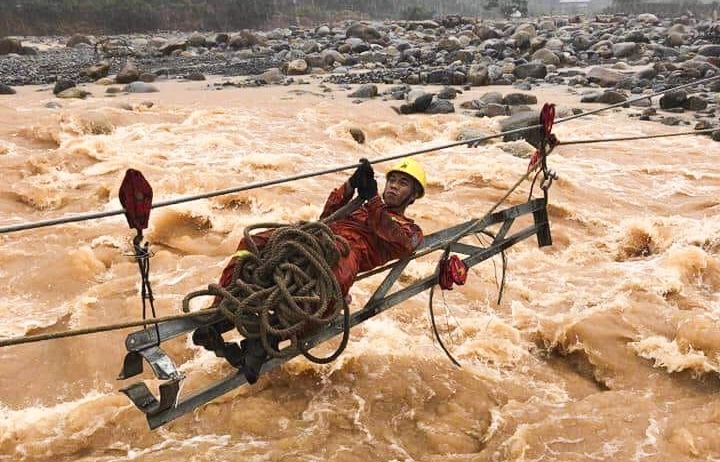 Thợ đường dây xử lý sự cố trên nước lũ