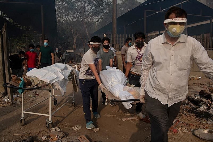 Các thành viên gia đình đang khiêng xác một bệnh nhân tử vong vì Covid-19 đi hỏa táng ở Ấn Độ.