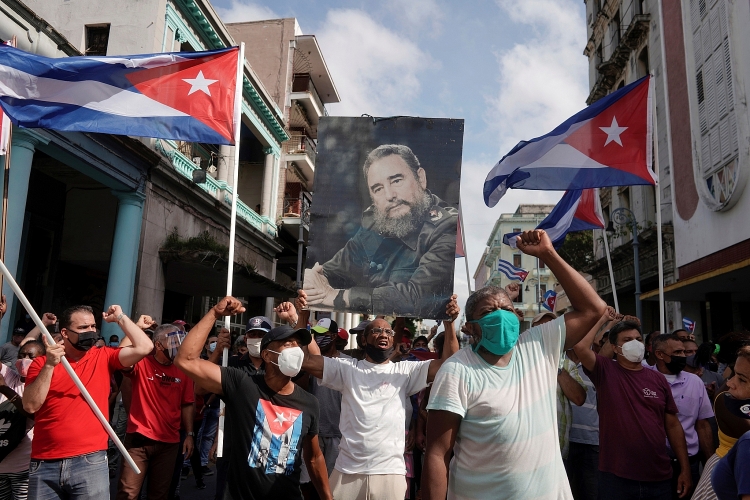 Người ủng hộ chính phủ Cuba cầm ảnh cố Chủ tịch Fidel Castro xuống đường ở Havana vào ngày 11.7.