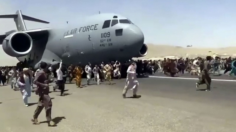 Người dân chạy trên đường băng khi chiếc C-17 chuẩn bị cất cánh.